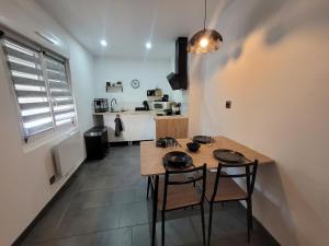 a room with a table and two chairs and a kitchen at Le Compostelle in Châtellerault