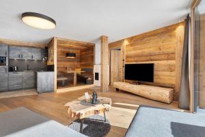 a living room with wooden walls and a large television at Chalet-Suite Wald in Selva dei Molini