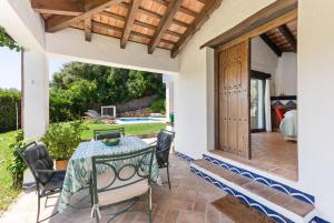 an outdoor dining room with a table and chairs at Villa Caty in Jimena de la Frontera