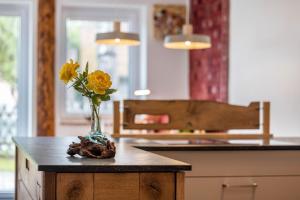 un vase avec des fleurs jaunes assis sur une table dans l'établissement Alb-Sonne Ferienwohnung, à Sonnenbühl 15 autres photos