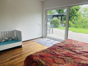 Un dormitorio con una cama y una puerta corrediza de vidrio. en Blick ins Grüne, en Daisendorf