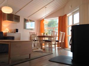 a kitchen and dining room with a table and chairs at Skipper-Lodge Süd in Hestoft