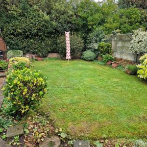 a garden with a sign in the middle of a yard at Single Bedroom in the main Bungalow in Wednesfield +1 photo