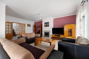 Una sala de estar con un sofá y un televisor. en Villa Delphin, en Lagos