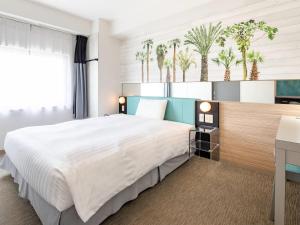 une chambre avec un grand lit et un bureau dans l'établissement Comfort Inn Naha Tomari Port, à Naha