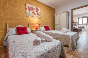 a bedroom with two beds with towels on them at Casa Rural Casita de la Cantera in La Lantejuela +37 photos