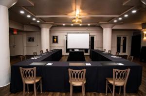 a conference room with a table and chairs and a white screen at Haywood Park Hotel, an Ascend Collection Hotel in Asheville