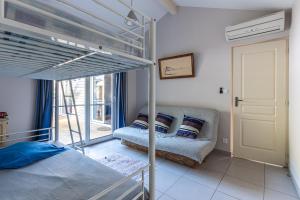 a bedroom with a bunk bed and a couch at Maison Le Moulleau in Arcachon