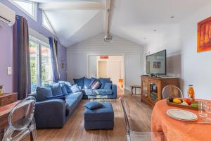 a living room with a blue couch and a tv at Maison Le Moulleau in Arcachon