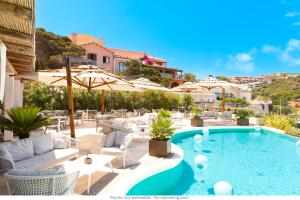 ein Pool mit Stühlen und Sonnenschirmen auf einer Terrasse in der Unterkunft Hotel Moresco in Santa Teresa Gallura