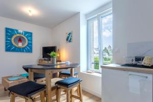 a kitchen with a table and two chairs in a room at Appartement - 50m de la mer in Fouesnant