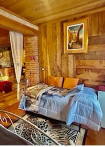 a bedroom with a bed in a room with wooden walls at Alba di Montanaria in Brosso