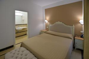 a bedroom with a bed and a sink and a mirror at Hotel Gargallo in Siracusa