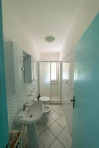 a white bathroom with a sink and a toilet at Il Mirto in Marciana