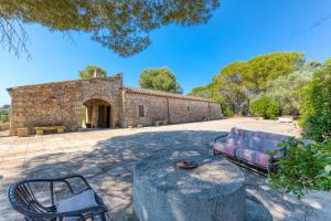 un bâtiment en pierre avec un canapé et une chaise dans l'établissement Tenuta Pizzola, à Nociglia