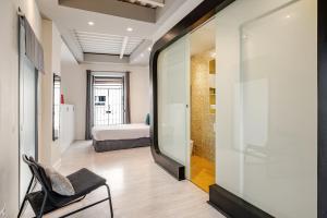 a room with a mirror and a chair and a bed at Dúplex el patio en centro de Sevilla in Seville