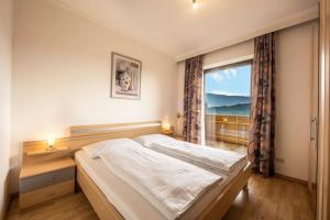 a bedroom with a bed and a large window at Residence Kronstein - Fewo 6 in Tesimo