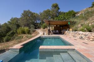 ein Schwimmbad in der Mitte eines Hügels in der Unterkunft La Isla Verde in Els Hostalets