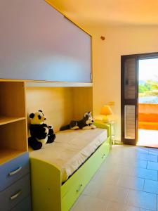 Capo CominoにあるOn The Sea Villa Fenicotteroの部屋のベッドに座る2匹のぬいぐるみパンダ