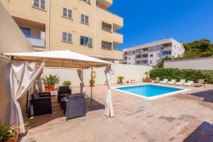 a patio with an umbrella and a swimming pool at Bona Mar in Cala Ratjada