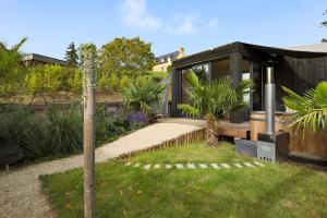 une maison noire dans un jardin avec des plantes dans l'établissement Ecolodge à 300m de la plage, à Pléneuf-Val-André