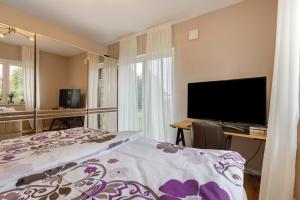 a bedroom with a bed and a desk with a television at Luxurious Family House in Tornesch