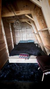 a bed in the attic of a wooden house at Cabaña misha in Chignahuapan
