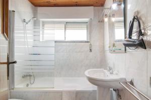 a white bathroom with a sink and a shower at Matinhos House in Faro +11 photos