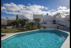 a large swimming pool in front of a building at San Salvador apartamento in Nerja