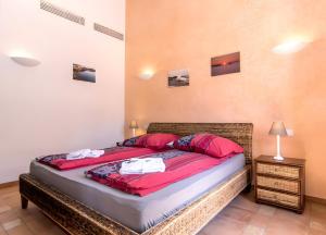 a bedroom with a large bed with red sheets at Pescadores in Cala Ratjada