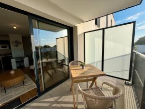 a balcony with a wooden table and chairs at Le Carnoët in Clohars-Carnoët