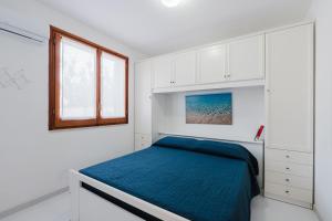 a white bedroom with a bed and a window at A_mare San Vito Lo Capo in San Vito lo Capo