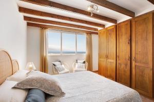een slaapkamer met een bed en een groot raam bij Salitre Suite Experiences in Tacoronte
