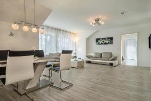 a dining room and living room with a table and chairs at Familien-Apartment 1 in Meersburg