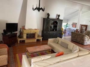 a living room with a couch and a tv at Penalva Beach House in Troia