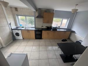 a kitchen with a sink and a washing machine at Cosy 3 Bedroom in Birmingham in Birmingham
