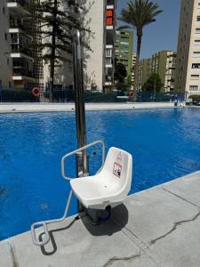 Ein weißer Stuhl steht neben einem Schwimmbecken in der Unterkunft Nuevo Acapulco in San Francisco