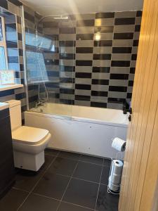 a bathroom with a toilet and a tub and a sink at Cosy 3 Bedroom in Birmingham in Birmingham