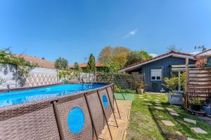 a backyard with a swimming pool and a house at Chalet studio bassin d'Arcachon in La Teste-de-Buch