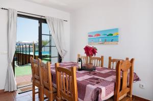 Un comedor con mesa y vista al mar. en Villa La Bonilla, en Playa Blanca