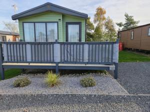 un banc devant une petite maison dans l'établissement Baywood View Lodge, à East Heslerton