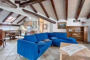 ein Wohnzimmer mit einem blauen Sofa und einem Tisch in der Unterkunft Au Petit Chevrot - Classic in Aosta