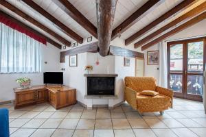 ein Wohnzimmer mit Fernseher und Sessel in der Unterkunft Au Petit Chevrot - Classic in Aosta