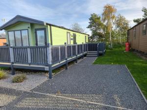 Ce mobile home dispose d'une terrasse couverte et d'une cour. dans l'établissement Baywood View Lodge, à East Heslerton