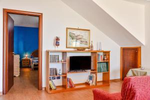 a living room with a tv on a book shelf at Villa Sovareto vista mare in Sciacca