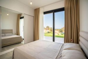 a bedroom with a bed and a large window at Modern Seaside Apartment with Walking Distance to the Beach in Bahçeli +29 photos