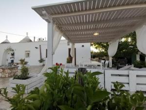 a white patio with a white pergola at Trullo Vito with pool in Martina Franca
