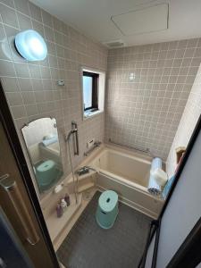 a bathroom with a tub and a toilet and a sink at Guesthouse Suisennosato in Konan