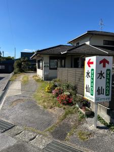 a house with a sign in front of it at Guesthouse Suisennosato in Konan