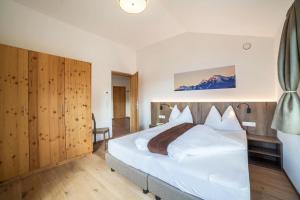 a bedroom with a large white bed in a room at Flatschhof - Apartment Cevedale in Castelbello-ciardes